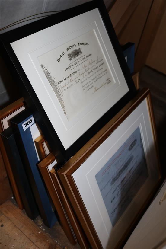 A collection of share certificates, mostly framed